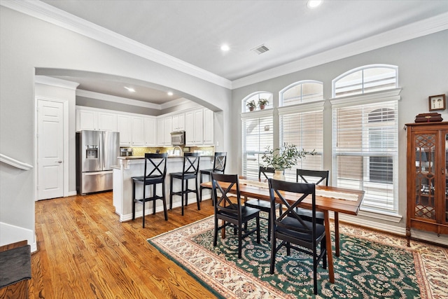 dining room featuring ornamental molding and light hardwood / wood-style flooring