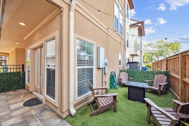 view of home's exterior with a yard, central AC, and a patio area