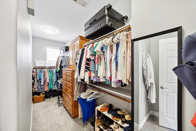 walk in closet with light carpet