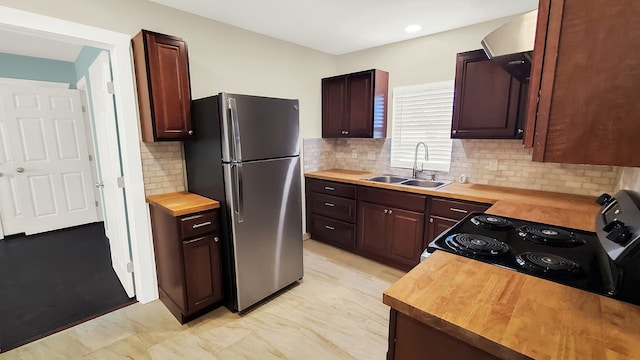 kitchen with stainless steel refrigerator, sink, range with electric cooktop, and butcher block countertops