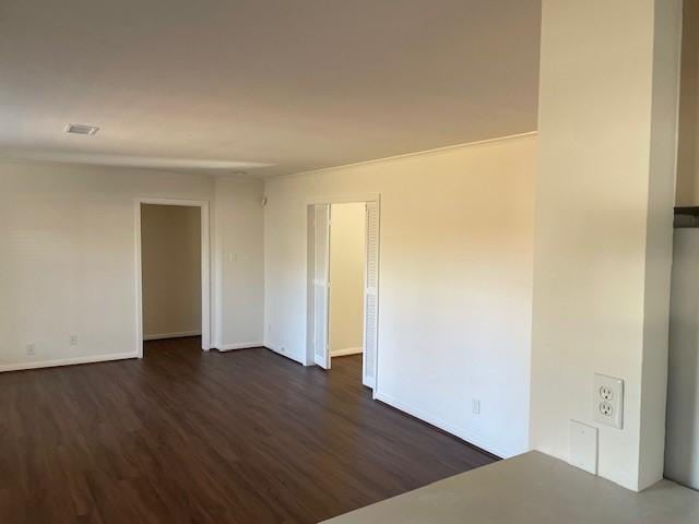 unfurnished room with dark wood-type flooring