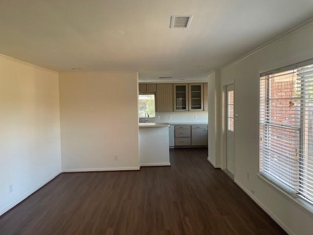 interior space with ornamental molding and dark hardwood / wood-style flooring