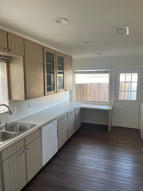 kitchen featuring white dishwasher, sink, dark hardwood / wood-style flooring, and ornamental molding