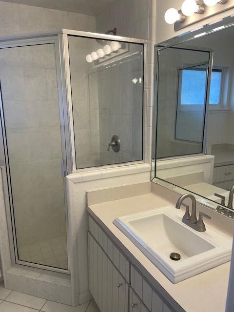 bathroom featuring vanity, tile patterned flooring, and a shower with shower door