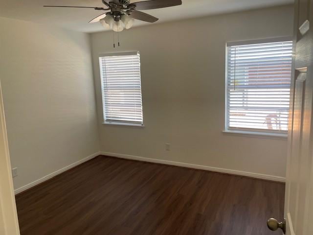 unfurnished room with dark hardwood / wood-style floors and ceiling fan