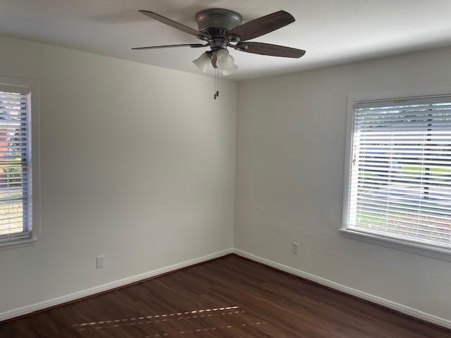 unfurnished room with dark hardwood / wood-style flooring and ceiling fan