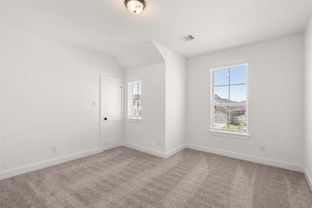 spare room with visible vents, light colored carpet, and baseboards