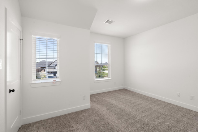 carpeted empty room with visible vents and baseboards