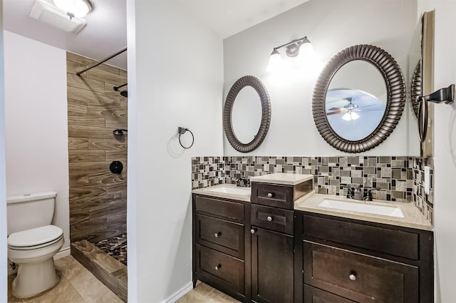 bathroom featuring tiled shower, vanity, toilet, and decorative backsplash