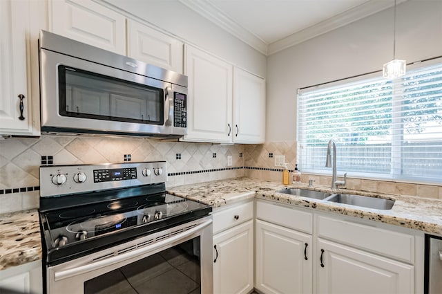 kitchen with pendant lighting, sink, crown molding, appliances with stainless steel finishes, and white cabinetry