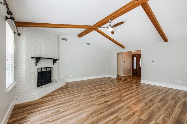 unfurnished living room featuring hardwood / wood-style flooring, ceiling fan, vaulted ceiling with beams, and a fireplace