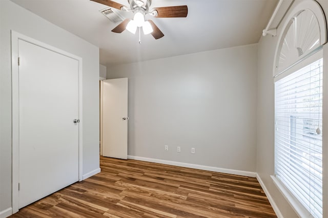 unfurnished bedroom featuring ceiling fan and dark hardwood / wood-style floors