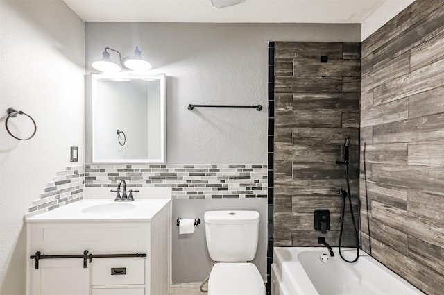 full bathroom featuring vanity, tiled shower / bath, tile walls, and toilet