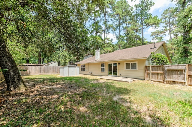 rear view of property with a shed, a patio area, and a lawn