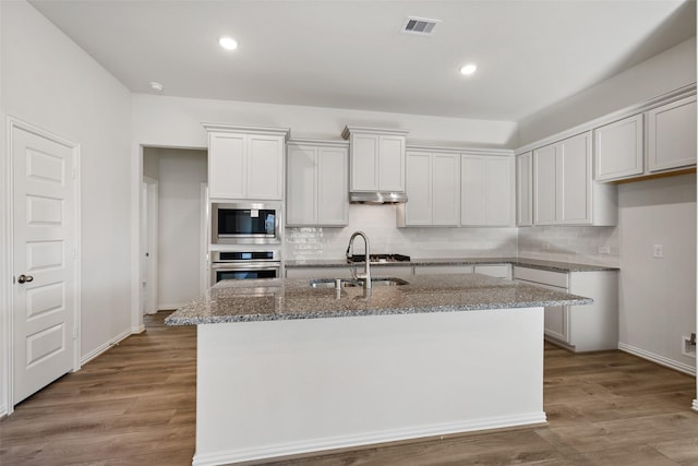 27603 Beachside Arbor Dr, Katy, TX 77493 - kitchen with appliances with stainless steel finishes, a sink, light stone countertops, decorative backsplash, and recessed lighting