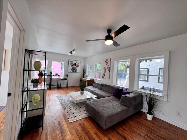 living room with ceiling fan, wood finished floors, and baseboards