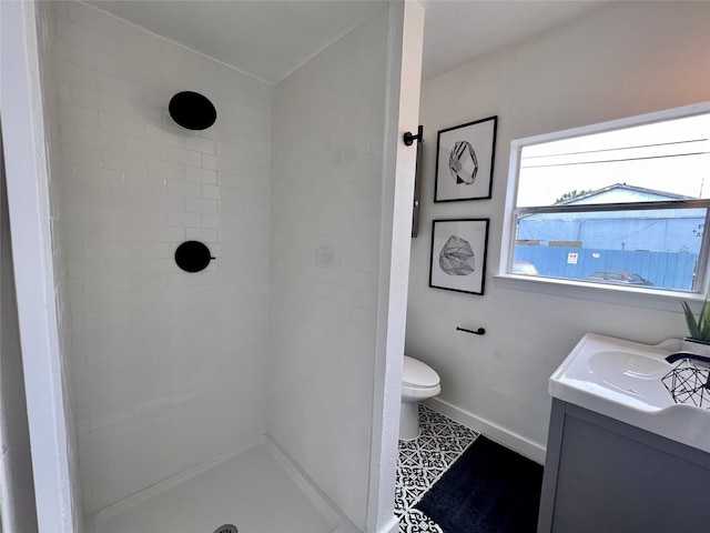 full bathroom featuring toilet, a shower, vanity, and baseboards