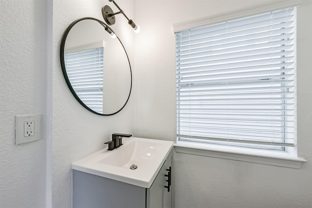 bathroom featuring a textured wall and vanity