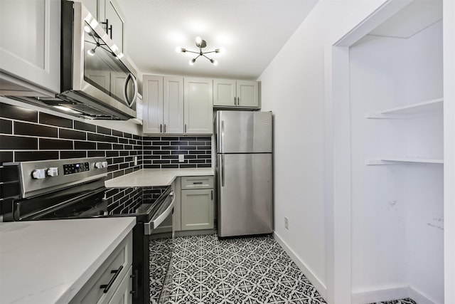 kitchen featuring appliances with stainless steel finishes, tasteful backsplash, gray cabinets, and open shelves