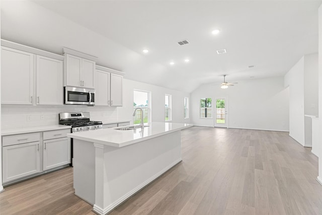5830 Westwood Shore Dr, Katy, TX 77493 - kitchen with appliances with stainless steel finishes, a sink, backsplash, a center island with sink, and ceiling fan