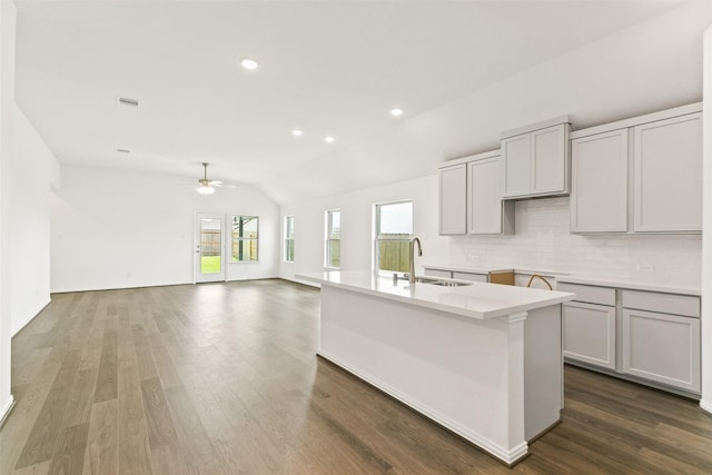 5830 Westwood Shore Dr, Katy, TX 77493 - kitchen with a ceiling fan, decorative backsplash, lofted ceiling, dark wood-style floors, and a center island with sink