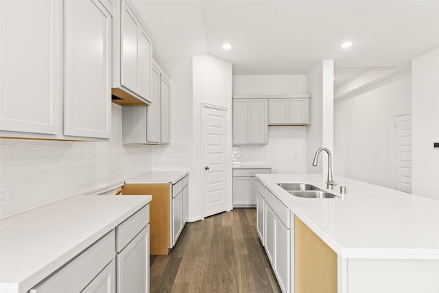 5830 Westwood Shore Dr, Katy, TX 77493 - kitchen with dark wood-style flooring, an island with sink, recessed lighting, decorative backsplash, and light countertops