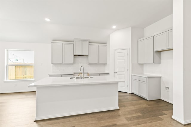 5830 Westwood Shore Dr, Katy, TX 77493 - kitchen with a center island with sink, backsplash, light countertops, wood finished floors, and recessed lighting