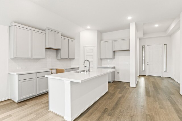 5830 Westwood Shore Dr, Katy, TX 77493 - kitchen with a kitchen island with sink, light wood finished floors, recessed lighting, light countertops, and gray cabinets