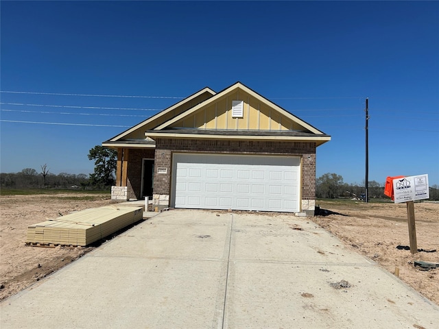 view of front of house with brick siding, board and batten siding, concrete driveway, and a garage