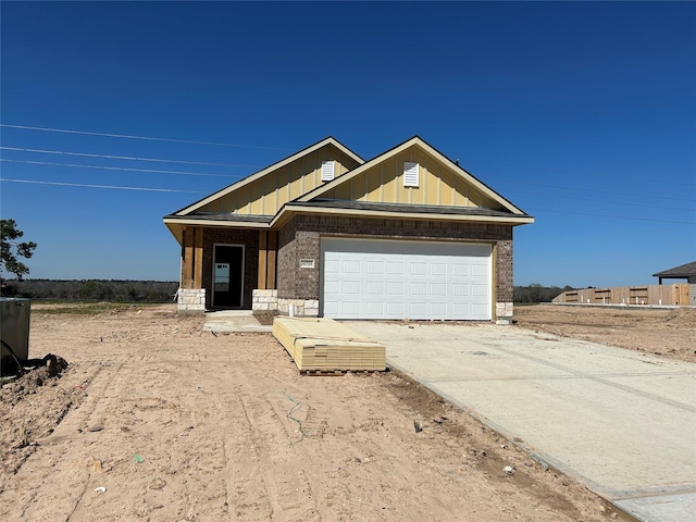 view of front of property featuring brick siding, board and batten siding, an attached garage, and driveway