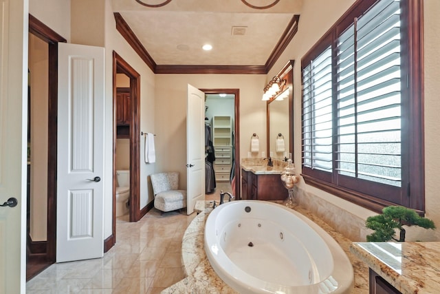 bathroom with ornamental molding, vanity, toilet, and tiled tub