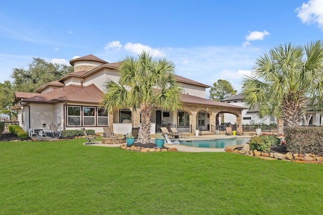 rear view of house featuring a yard and a patio