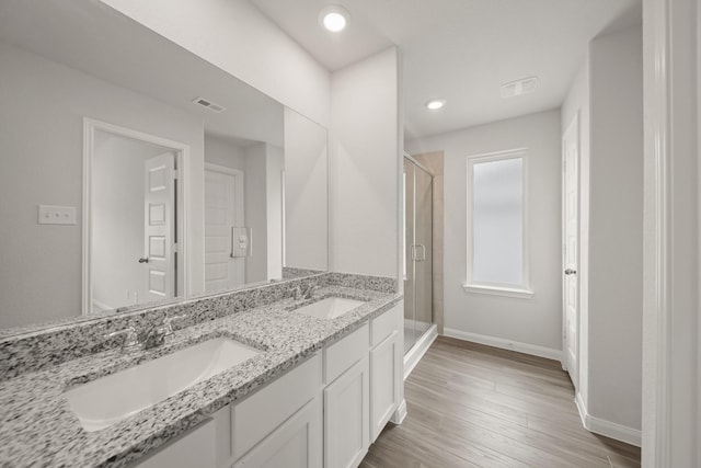 full bath with a sink, a stall shower, baseboards, and visible vents