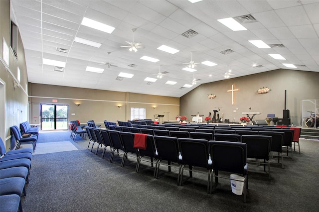 carpeted home theater room featuring a drop ceiling and vaulted ceiling