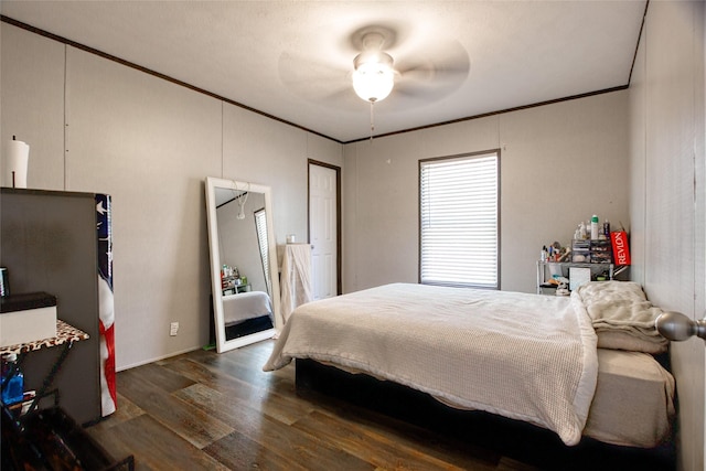 bedroom with crown molding, ceiling fan, and dark hardwood / wood-style flooring