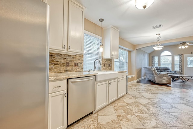 kitchen featuring pendant lighting, stainless steel appliances, sink, and tasteful backsplash