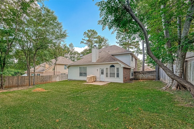 rear view of property with a lawn and a patio area