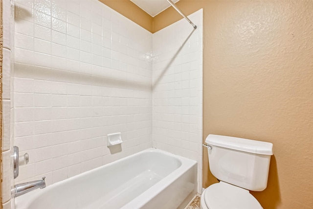 bathroom with tiled shower / bath combo and toilet