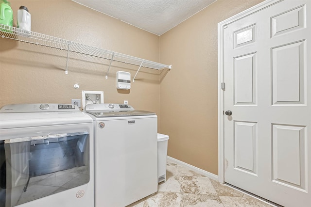 washroom with separate washer and dryer and a textured ceiling