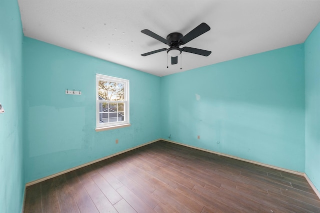 unfurnished room with dark hardwood / wood-style flooring and ceiling fan