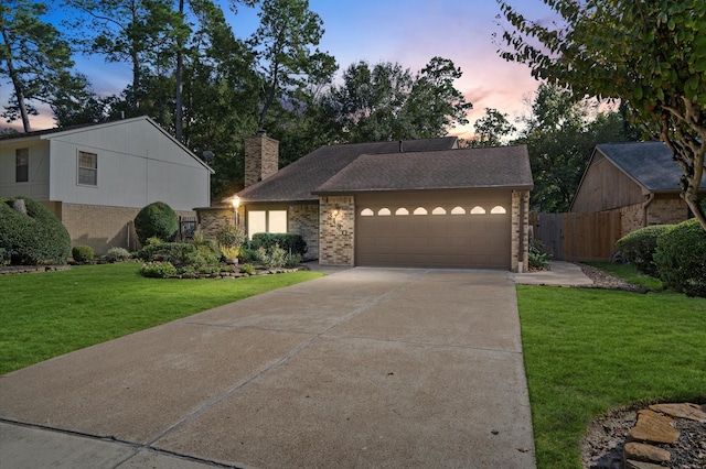 view of front of home featuring a garage and a yard