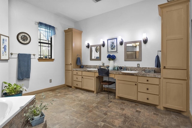 bathroom featuring visible vents, vanity, baseboards, stone finish floor, and tiled tub