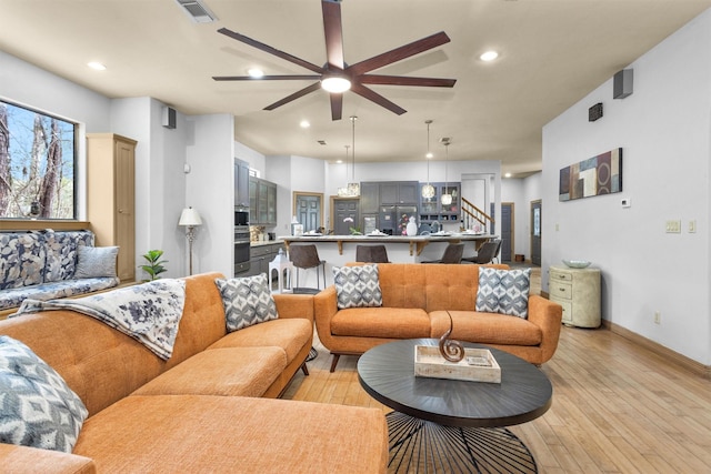 living area featuring light wood finished floors, visible vents, and recessed lighting