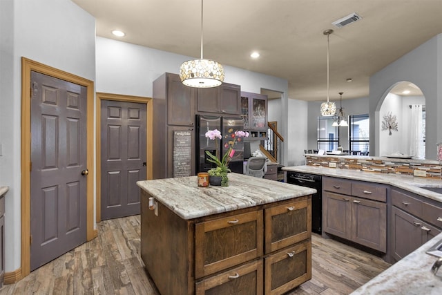 kitchen featuring visible vents, a kitchen island, light wood-type flooring, stainless steel fridge, and dishwasher