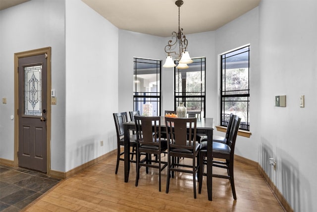 dining space with an inviting chandelier, baseboards, and hardwood / wood-style floors