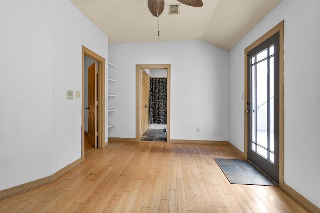 spare room with visible vents, ceiling fan, vaulted ceiling, and light wood-style flooring