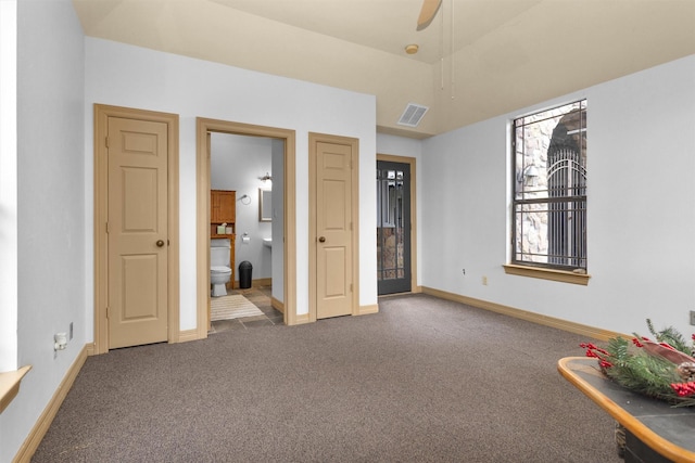 unfurnished bedroom with baseboards, visible vents, connected bathroom, and carpet flooring