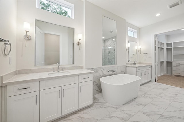 full bathroom featuring marble finish floor, a marble finish shower, and a sink