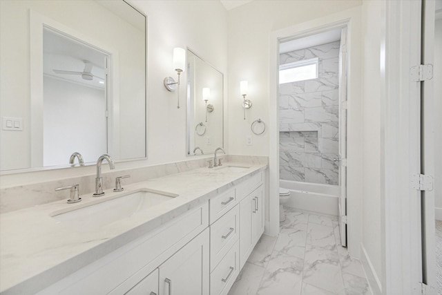 full bath featuring double vanity, marble finish floor, toilet, and a sink