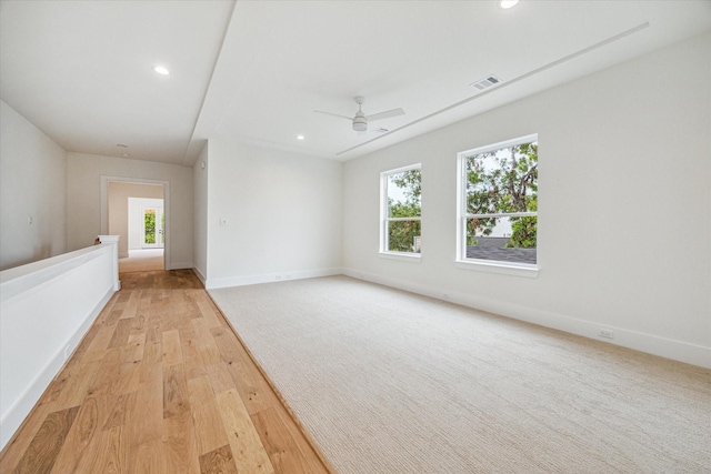 spare room with recessed lighting, visible vents, a ceiling fan, light wood-type flooring, and baseboards